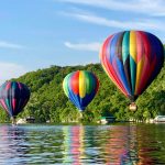 The second place winner of the 2018 Photo Contest. Pictures three hot air balloons nearly touching down on the St. Croix River.
