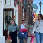 3 girls with shopping bags smiling and walking for a girls getaway to Stillwater, Minnesota
