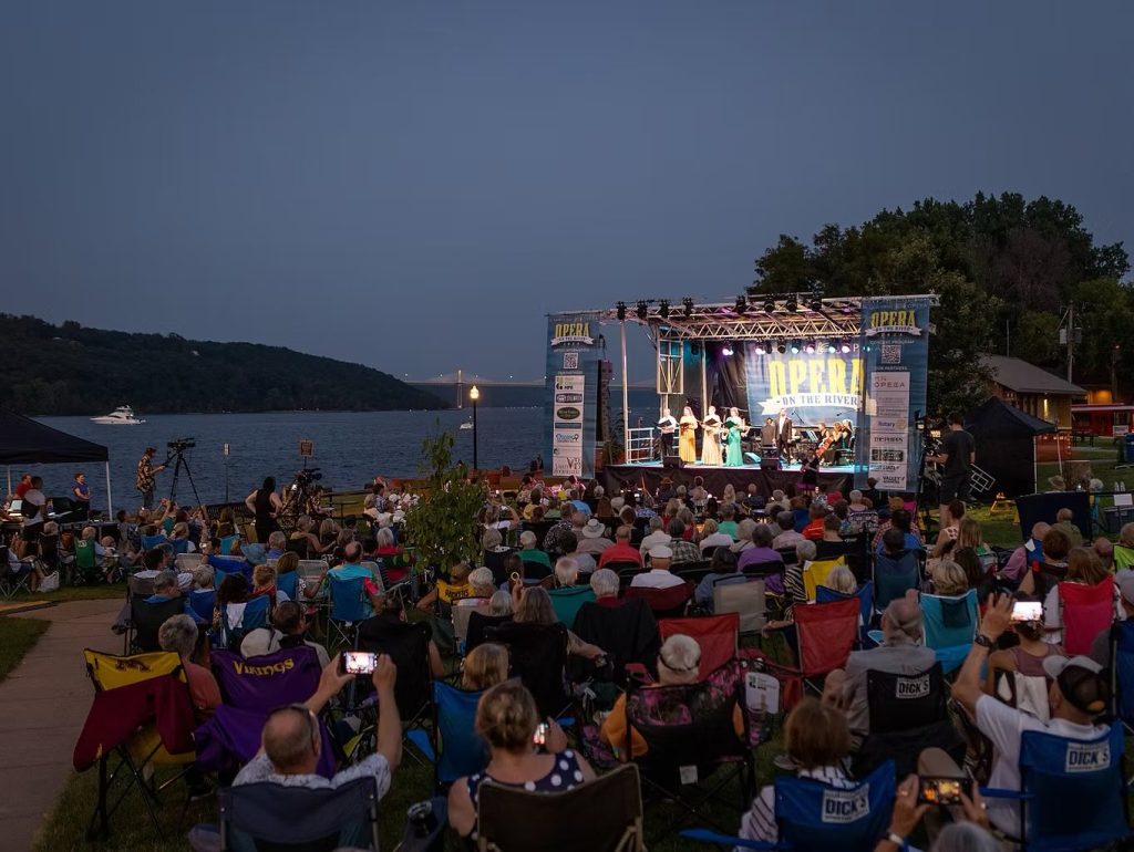 people watching Opera on the River as the sunset