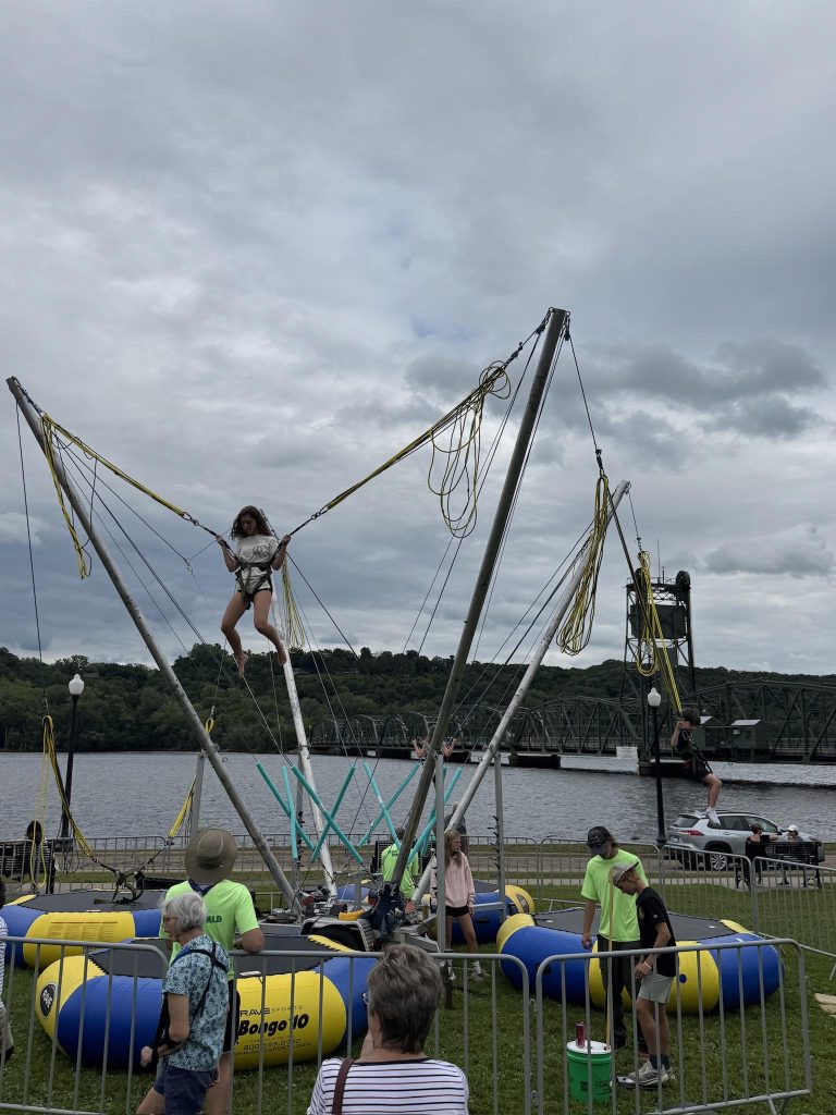 A person on a trampoline-harness apparatus outside