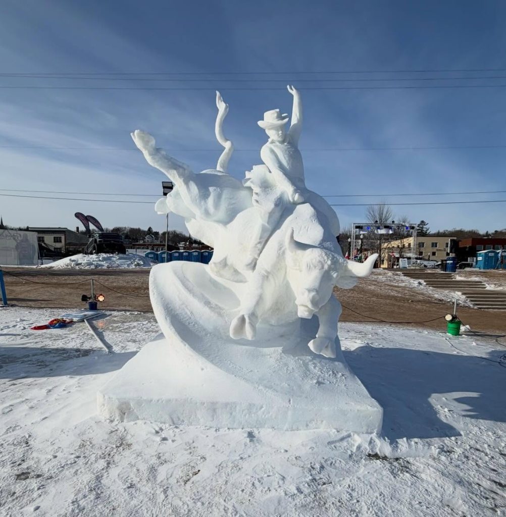 snow sculpture of a cowboy riding a bull